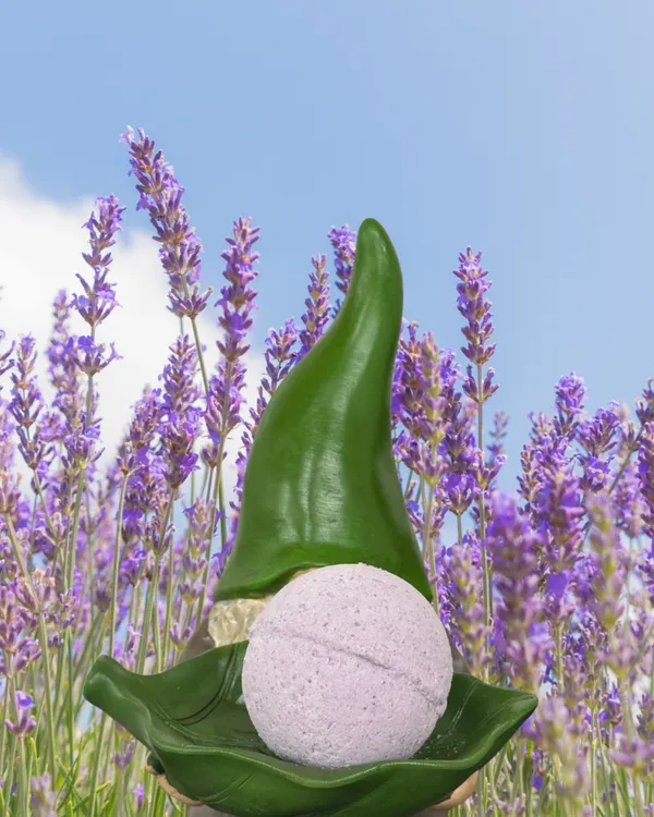Gnome figurine with a handmade bath bomb in a lavender field